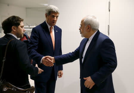 U.S. Secretary of State John Kerry shakes hands with Iranian Foreign Minister Mohammad Javad Zarif after the International Atomic Energy Agency (IAEA) verified that Iran has met all conditions under the nuclear deal, in Vienna January 16, 2016. REUTERS/Kevin Lamarque