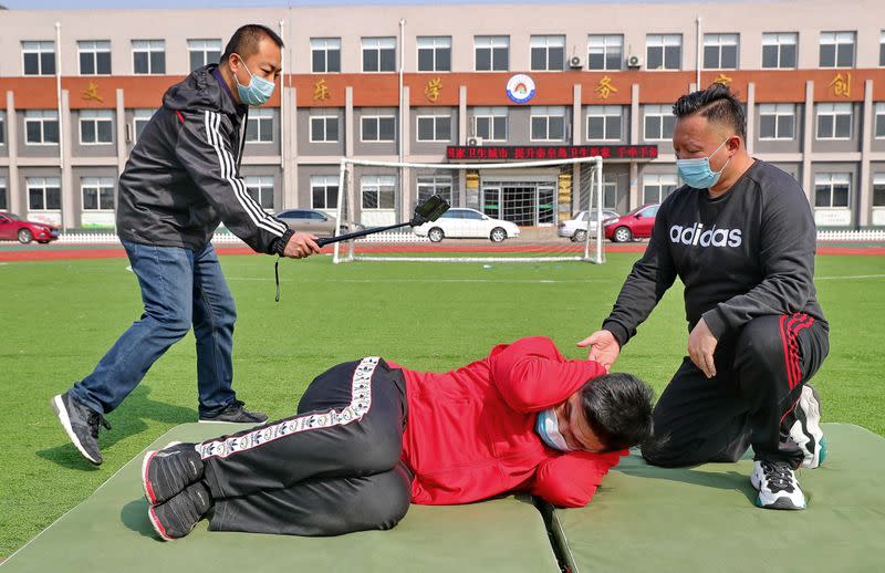 Teachers wearing face masks take part in a recording of a lesson on stampede prevention at a primary school, as students' returning to school has been delayed by an outbreak of the novel coronavirus disease (COVID-19), in Qinhuangdao