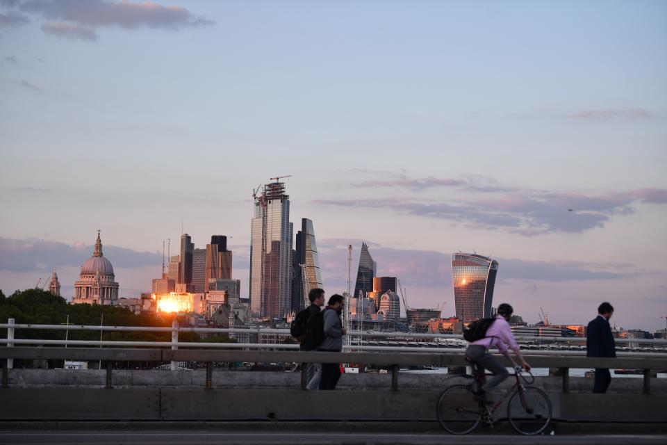 The setting sun is reflected in the office buildings of the City of London on May 21, 2019. (Photo by Ben STANSALL / AFP)        (Photo credit should read BEN STANSALL/AFP/Getty Images)