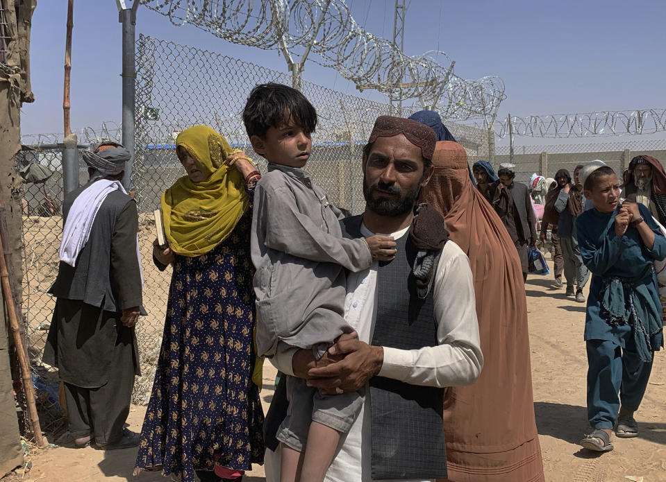 Afghan families cross the border into Pakistan from Afghanistan, in Chaman, Pakistan, Thursday, Aug. 19, 2021. Chaman, is a key border crossing between Pakistan and Afghanistan, normally thousands of Afghans and Pakistanis cross daily and a steady stream of trucks passes through, taking goods to Afghanistan. (AP Photo)