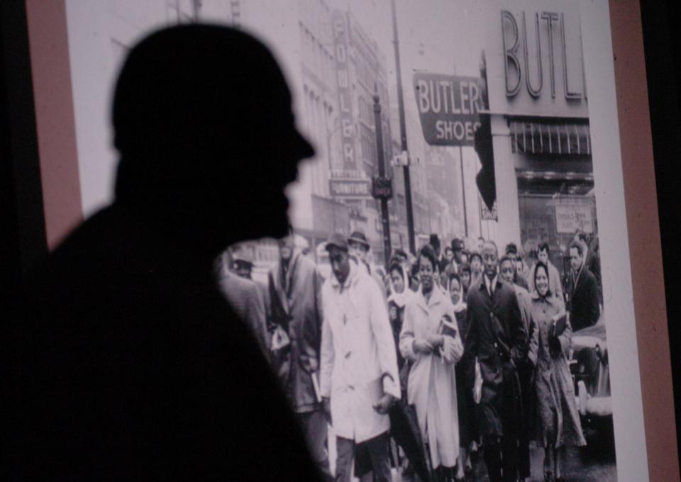 Robert J. Booker, left, is silhouetted against a projected photograph of Knoxville College students marching around downtown Knoxville through all the stores with segregated lunch counters in 1960 as he speaks at the Beck Cultural Exchange Center about his experiences with Knoxville's civil rights movement.