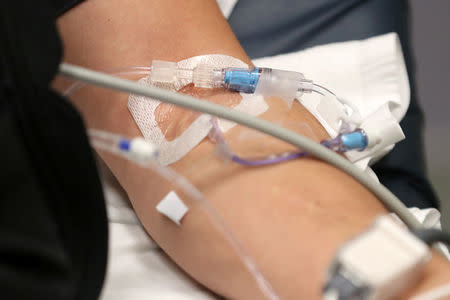 Joshua Lagade of Vista, California, gets fluids in an IV as he lies on a bed with the flu in the emergency room at Palomar Medical Center in Escondido, California, U.S., January 18, 2018. REUTERS/Mike Blake