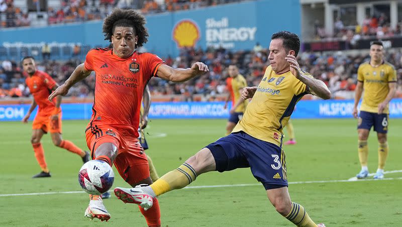 Houston Dynamo midfielder Adalberto Carrasquilla (20) and Real Salt Lake defender Bryan Oviedo (3) converge on the ball during the first half of an MLS playoff soccer match, Sunday, Oct. 29, 2023, in Houston. 