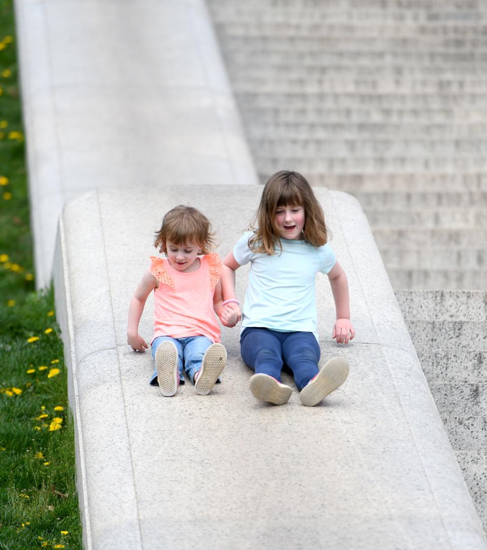 Kathryn Smith, 4, gets a hand from sister, Elisabeth Smith, 6, of Canton Township, as they ride down the steps at McKinley Monument on and unseasonably warm day.