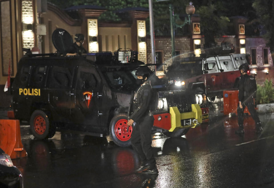 Officers are deployed outside the National Police Headquarters following a suspected militant attack in Jakarta, Indonesia, Wednesday, March 31, 2021. A woman entered the Indonesian National Police Headquarters in Jakarta and pointed a gun at several officers before being shot dead by police, in the latest in a series of militant attacks in the world's most populous Muslim nation. (AP Photo/Dita Alangkara)