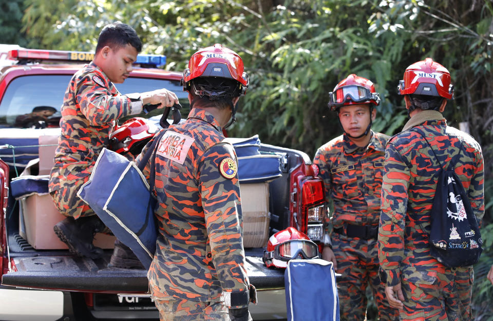 Fire and Rescue team prepare for their operation near the site of a landslide at an organic farm in Batang Kali, Malaysia, Friday, Dec. 16, 2022. Dozens of Malaysians were believed to have been at a tourist campground in Batang Kali, outside the capital of Kuala Lumpur, when the incident occurred, said a district police chief. (AP Photo/FL Wong)