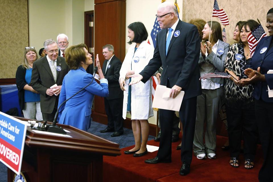 Pelosi blows a kiss to AFSCME President Saunders at a rally to celebrate Obamacare at the U.S. Capitol in Washington