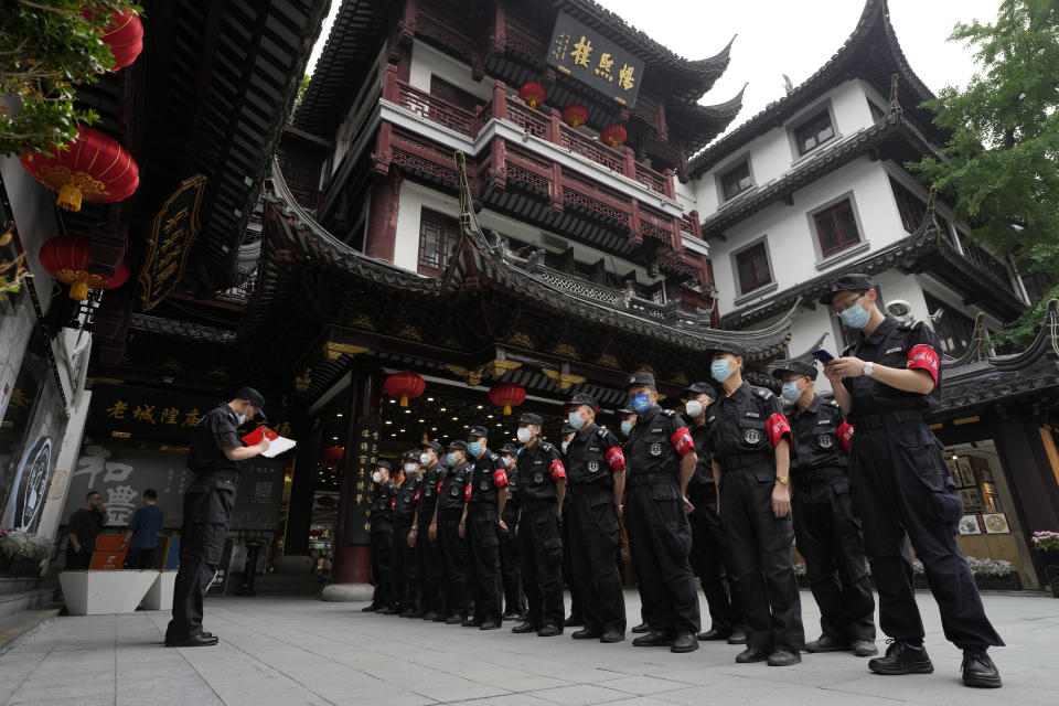 Security guards prepare for duty at the Yu Garden Mall, Thursday, June 2, 2022, in Shanghai. Traffic, pedestrians and joggers reappeared on the streets of Shanghai on Wednesday as China's largest city began returning to normalcy amid the easing of a strict two-month COVID-19 lockdown that has drawn unusual protests over its heavy-handed implementation. (AP Photo/Ng Han Guan)