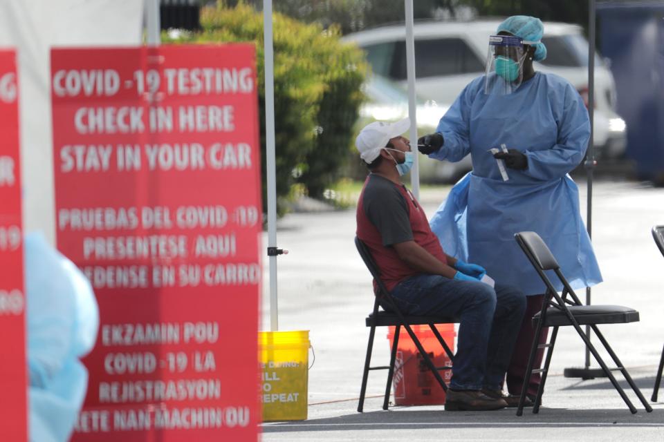 A health care worker administers a COVID-19 test at the Martin Luther King, Jr. Clinica Campesina Health Center in Homestead, Fla., in this July 6, 2020, file photo.