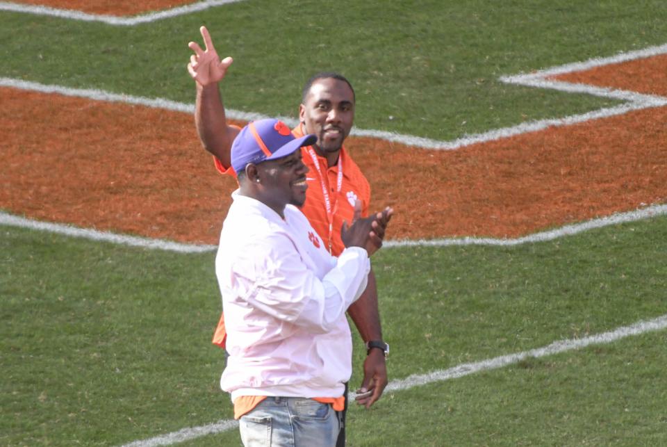 Former Clemson greats CJ Spiller, left, and James Davis wave to the crowd during a break in the first quarter at Memorial Stadium in Clemson, S.C., Saturday, October 20, 2018.