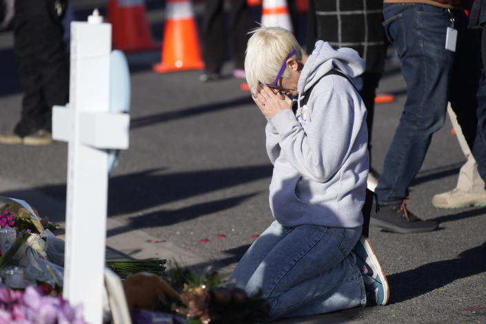 Dallas Dutka of Broomfield, Colo., prays by a makeshift memorial, Tuesday Nov. 22, 2022, for the victims of a mass shooting at a gay nightclub in Colorado Springs, Colo. Dutka's cousin, Daniel Aston, was killed in the shooting. (AP Photo/David Zalubowski)