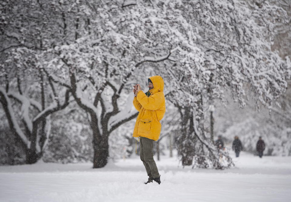 A person takes a photo with their phone during a major snowstorm in Ottawa on Saturday, Jan. 16, 2021. (Justin Tang/The Canadian Press via AP)