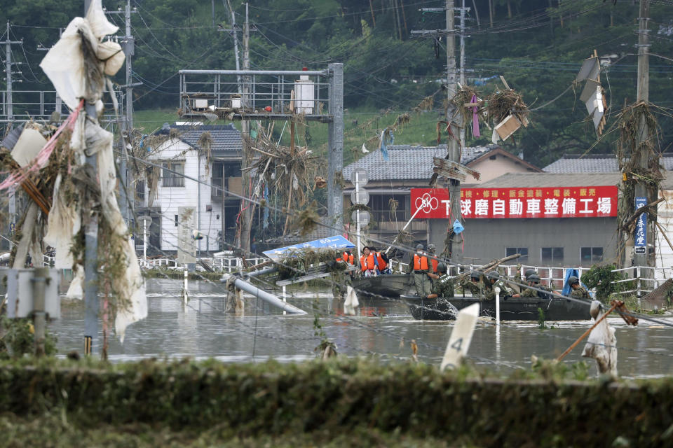 Japan Ground Self-Defense Force members evacuate people to a safer place by boat in Kuma village, Kumamoto prefecture, southwestern Japan, Sunday, July 5, 2020. Heavy rain in the Kumamoto region triggered flooding and mudslides Saturday and left dozens still being stranded at their homes and other facilities. (Kyodo News via AP)