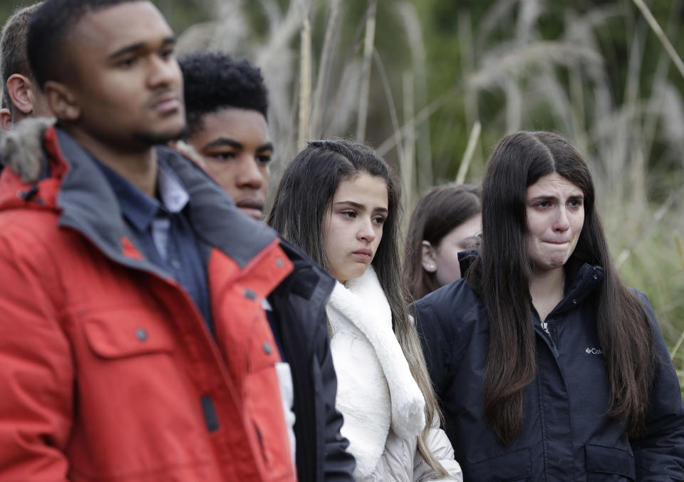 Students from the Marjory Stoneman Douglas High School in Parkland, Florida, react after planting trees at Halswell Quarry Park Conservation Area on the outskirts of Christchurch, New Zealand, Tuesday, July 24, 2018. The 28 students who survived the Feb. 14, 2018, mass-shooting at the Florida school are visiting New Zealand to learn more about sustaining youth movements. After planting the native totara trees on Tuesday, they recounted memories of their former classmates and teachers in a ceremony that brought many to tears. (AP Photo/Mark Baker)