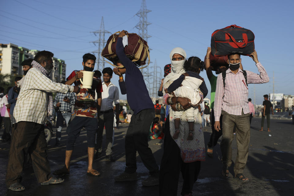 In this Saturday, March 28, 2020, file photo, locals provide drinking water to Indian migrant laborers making their way on foot to their respective villages following a lockdown amid concern over spread of coronavirus in New Delhi, India. Over the past week, India’s migrant workers - the mainstay of the country’s labor force - spilled out of big cities that have been shuttered due to the coronavirus and returned to their villages, sparking fears that the virus could spread to the countryside. It was an exodus unlike anything seen in India since the 1947 Partition, when British colothe subcontinent, with the 21-day lockdown leaving millions of migrants with no choice but to return to their home villages. (AP Photo/Altaf Qadri, File)