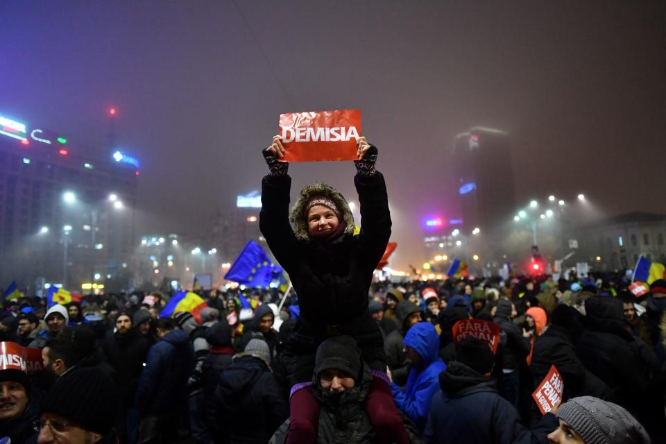 A woman holds a banner reading 'Resignation' during a protest rally against the government in Bucharest on Feb. 6, 2017. Romania's government formally repealed contentious corruption legislation that has sparked the biggest protests since the fall of dictator Nicolae Ceausescu in 1989, ministerial sources said.