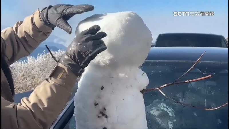 上山賞雪的旅客開心在車上堆雪人。