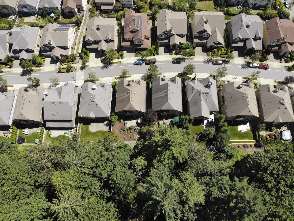 In this photo taken July 24, 2019, houses stand adjacent to a forest in the Seattle suburb of Issaquah, Wash. Experts say global warming is changing the region’s seasons, bringing higher temperatures, lower humidity and longer stretches of drought. And that means wildfire risks in coming years will extend into areas that haven’t experienced major burns in residents’ lifetimes. (AP Photo/Elaine Thompson)