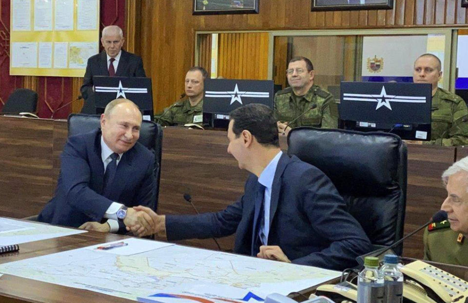 This image released by the Syrian Presidency shows Russian President Vladimir Putin, left, meeting with Syrian President Bashar Assad, center, in Damascus, Syria on Tuesday, Jan. 7, 2020. Putin's visit is the second to the war-torn country where his troops have been fighting alongside Syrian government forces since 2015. (Syrian Presidency via AP)