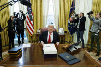 FILE - In this Friday, Dec. 22, 2017 file photo, President Donald Trump speaks to reporters after signing a tax bill and continuing resolution to fund the government, in the Oval Office of the White House in Washington. Trump’s true financial picture has gotten renewed scrutiny in the wake of a New York Times report in September 2020 that he declared hundreds of millions in losses in recent years, allowing him to pay just $750 in taxes the year he won the presidency, and nothing for 10 of 15 years before that. (AP Photo/Evan Vucci)