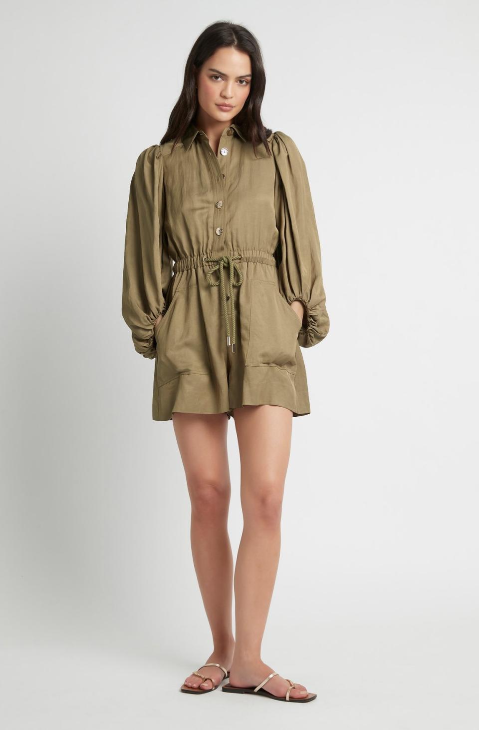 Woman stands in khaki long-sleeved Mirage playsuit from Sheike, $169.95