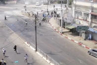 In this image from video obtained by The Associated Press, soldiers, upper right, chase protesters in Yangon, Myanmar on March 3, 2021. Since its takeover of the government in February, the Myanmar military has been using torture against those it has detained in a methodical and systemic way across the country, The Associated Press has found in rare interviews with 28 people imprisoned and released in recent months. (AP Photo)