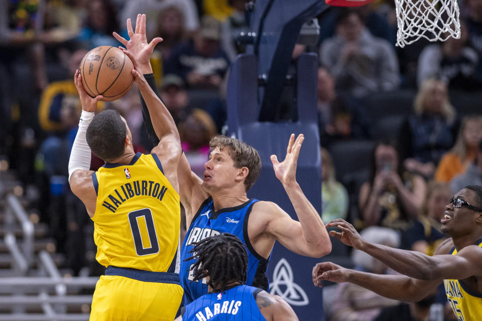 Orlando Magic center Moritz Wagner, center top, attempts to block a shot by Indiana Pacers guard Tyrese Haliburton (0) during the first half of an NBA basketball game in Indianapolis, Sunday, Nov. 19, 2023. (AP Photo/Doug McSchooler)