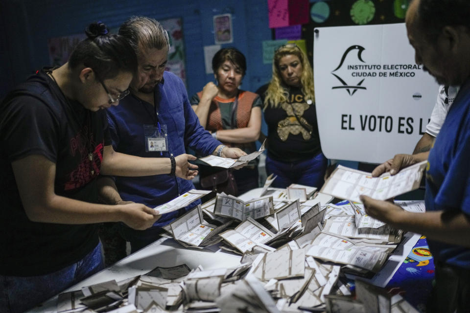 Electoral officials and poll watchers count votes after polls closed during general elections in Mexico City, Sunday, June 2, 2024. (AP Photo/Matias Delacroix)
