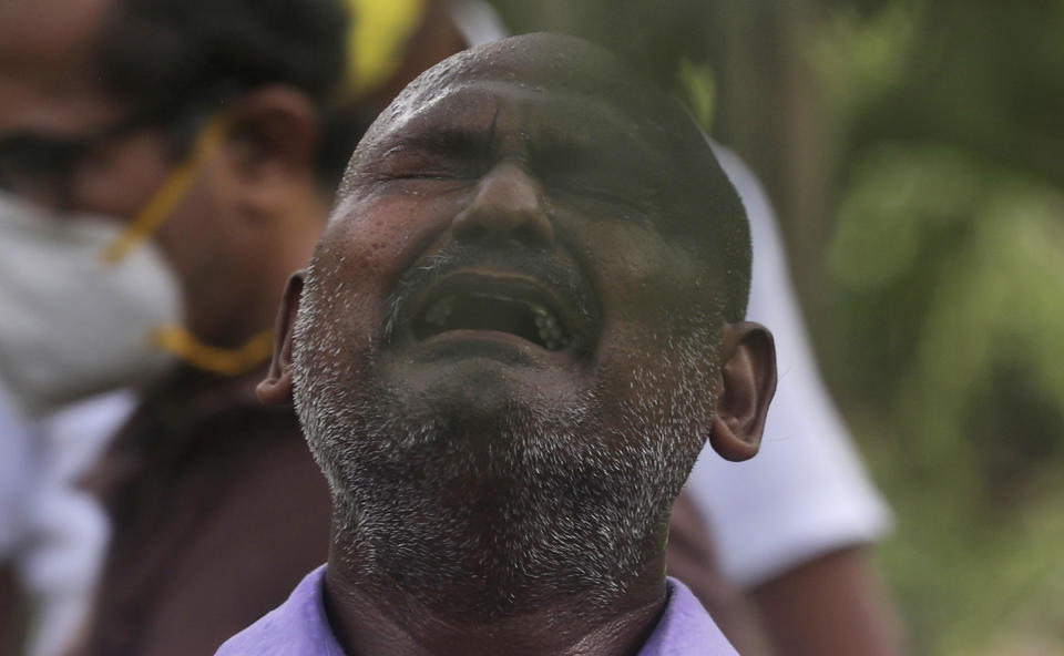 A man wails during the burial of a relative who died of COVID-19, at a cemetery in Mumbai, India, Tuesday, June 23, 2020. Some Indian states Tuesday were considering fresh lockdown measures to try to halt the spread of the virus in the nation of more than 1.3 billion. (AP Photo/Rafiq Maqbool)