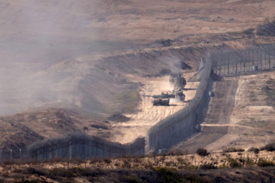 A picture taken from southern Israel along the border with the Gaza Strip shows Israeli army vehicles crossing the border into Gaza, on Nov. 6, 2023 amid ongoing battles between Israel and the Palestinian militant group Hamas.