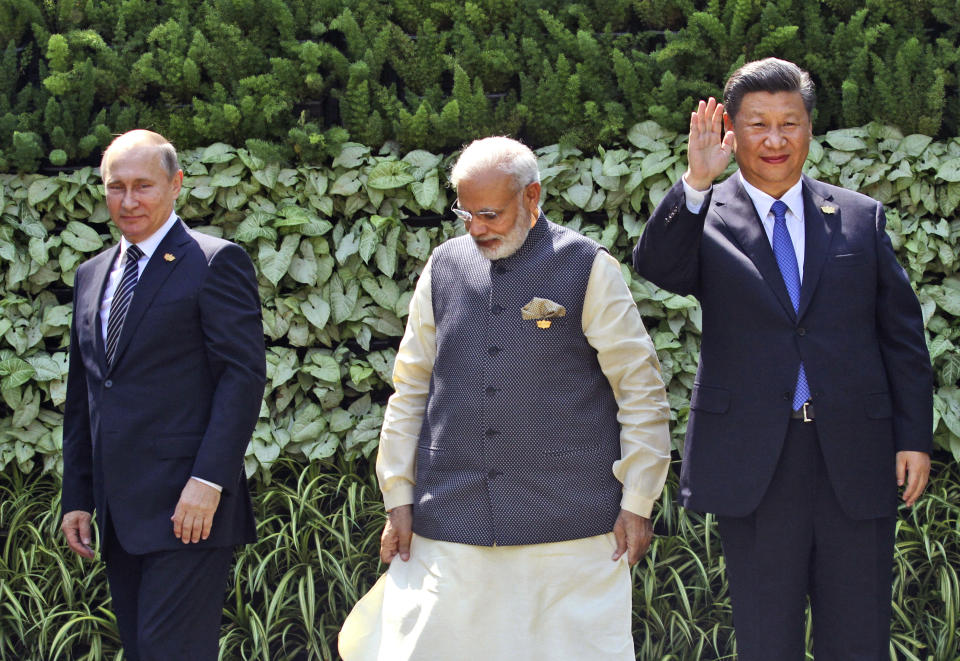 FILE- Russian President Vladimir Putin, Indian Prime Minister Narendra Modi, and Chinese President Xi Jinping stand at the start of the BRICS Summit in Goa, India, Oct. 16, 2016. Ahead of the G20 summit of leading economies, India has promoted itself as a rising global star with the potential to bridge the gap between the West and Russia. That stance also will be put to the test during the summit. So far, none of the G20 meetings this year have been able to agree on wording about Russia's war in Ukraine. Both Putin and Xi are not attending the summit but are sending representatives. (AP Photo/ Anupam Nath, File)