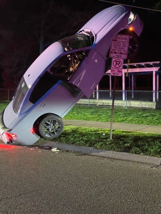 An Ann Arbor crash on April 26, 2024 left a car stuck atop a street sign, police say. (Courtesy Ann Arbor Police Department0