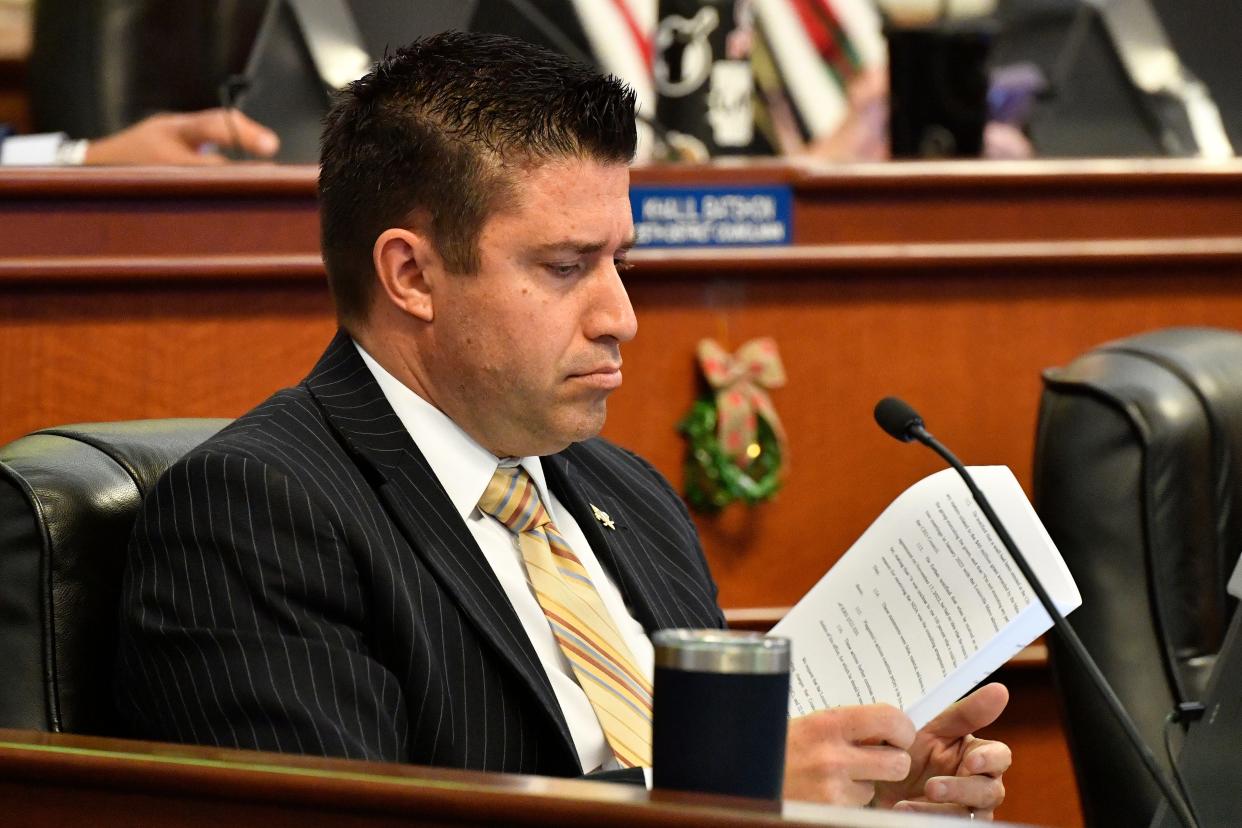Louisville Metro Council District 19 Representative Anthony Piagentini looks over the charging documents as they were read into the record during the Metro council meeting in the Louisville Metro Council chambers, Thursday, Nov. 30 2023 in Louisville Ky.