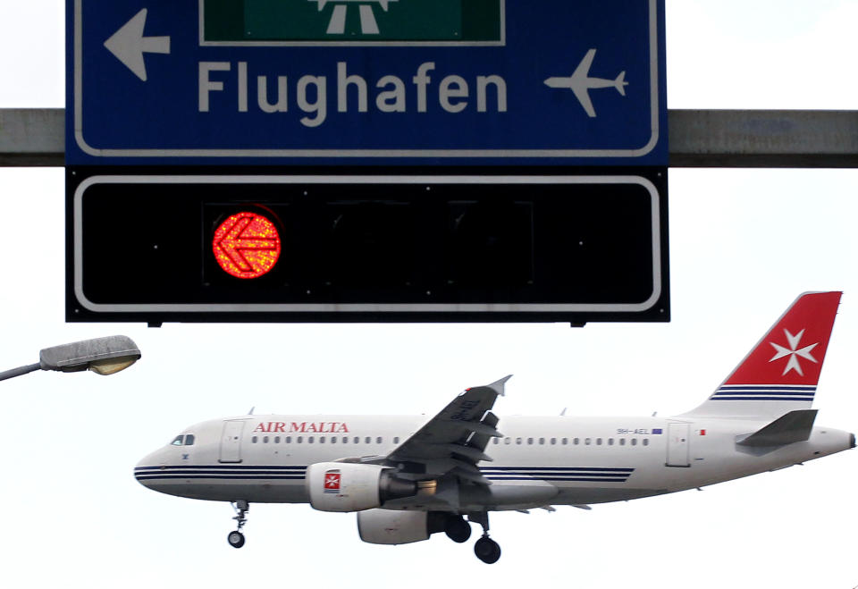 A jet of Air Malta is seen behind a traffic sign during its approach for a landing at Zurich Airport, Switzerland. Photo: Arnd Wiegmann/Reuters