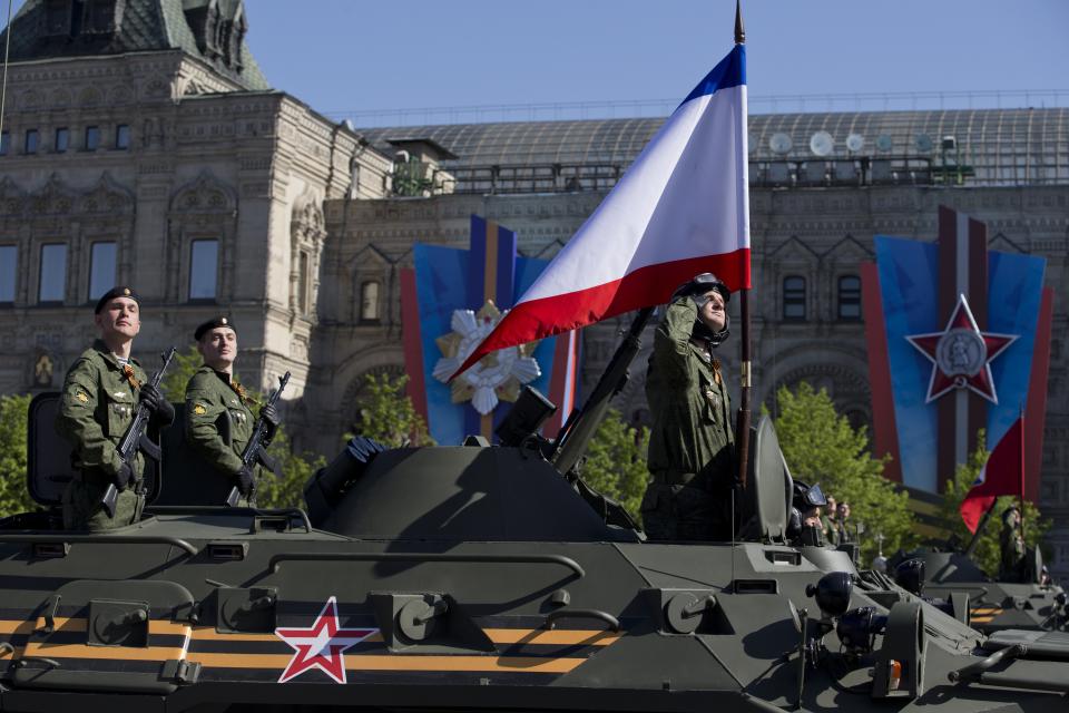 Russian troops ride an APC with a Crimean flag during the Victory Day Parade, which commemorates the 1945 defeat of Nazi Germany in Moscow, Russia, Friday, May 9, 2014. Thousands of Russian troops march on Red Square in the annual Victory Day parade in a proud display of the nation's military might amid escalating tensions over Ukraine. (AP Photo/Pavel Golovkin)