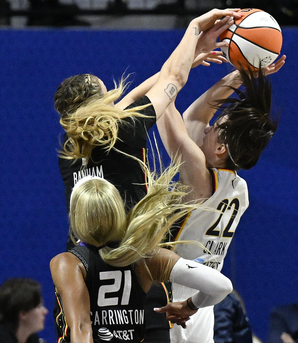 Connecticut Sun guard Rachel Banham (1) blocks a shot attempt by Indiana Fever guard Caitlin Clark (22) during the second quarter of a WNBA basketball game, Tuesday, May 14, 2024, in Uncasville, Conn. (AP Photo/Jessica Hill)