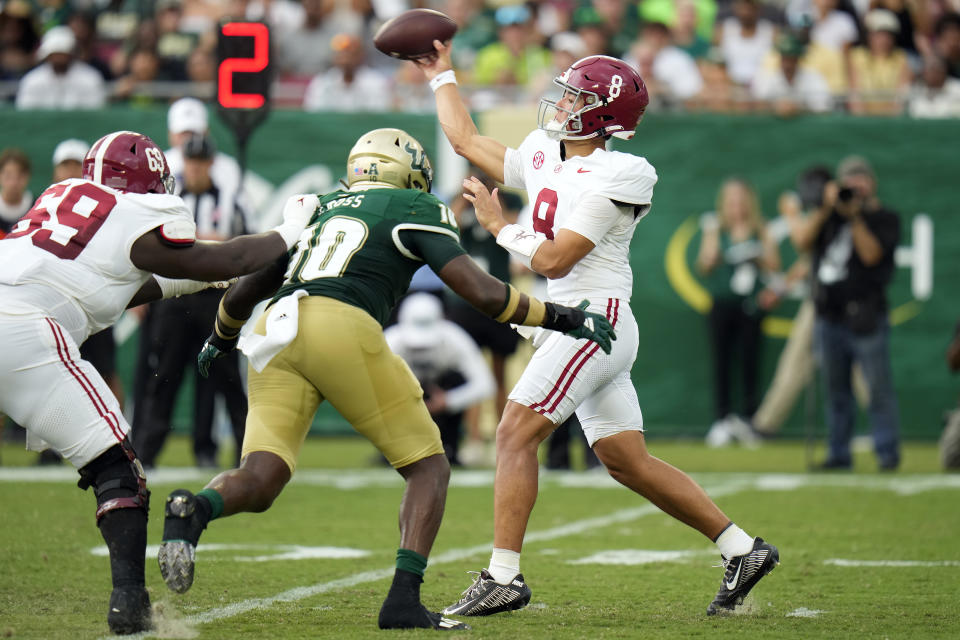 Alabama quarterback Tyler Buchner (8) gets hit by South Florida defensive end Jonathan Ross (10) as he throws a pass during the first half of an NCAA college football game Saturday, Sept. 16, 2023, in Tampa, Fla. (AP Photo/Chris O'Meara)