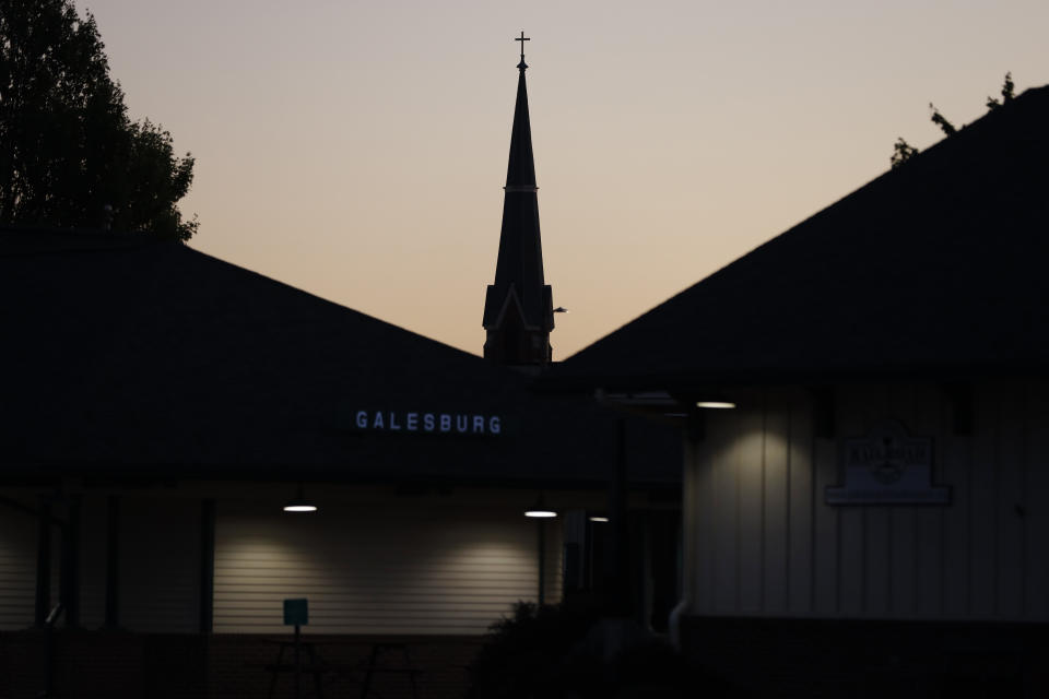 The steeple of the Corpus Christi Catholic Church is silhouetted against the evening sky, Monday, June 14, 2021, in Galesburg, Ill. Settled more than 180 years ago, Galesburg was built around Knox College, founded by Presbyterians from upstate New York seeking a Christian school on the western frontier. The city soon became home to Illinois' first anti-slavery society. (AP Photo/Shafkat Anowar)