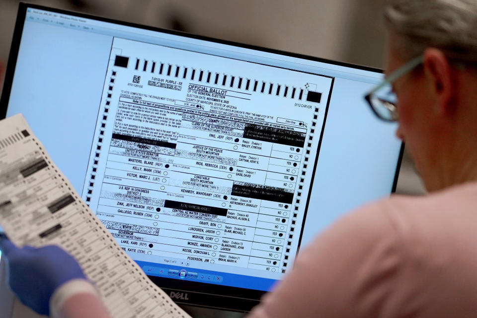 FILE - An election worker verifies a ballot on a screen inside the Maricopa County Recorders Office, Thursday, Nov. 10, 2022, in Phoenix. On Friday, Dec. 2, The Associated Press reported on stories circulating online incorrectly claiming Arizona’s Maricopa County announced that more than 540,000 voters visited voting centers on Election Day and that only 248,000 Election Day ballots were counted. Therefore, the county “lost” some 292,000 votes. (AP Photo/Matt York, File)