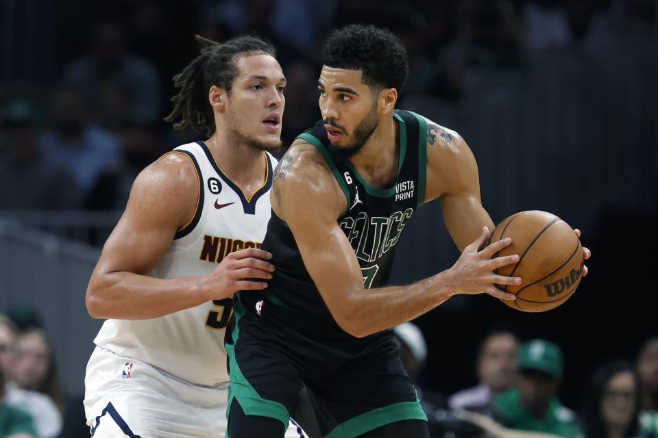 Boston Celtics' Jayson Tatum holds the ball away from Denver Nuggets' Aaron Gordon during the second half of an NBA basketball game, Friday, November 11, 2022, in Boston.  (AP Photo/Michael Dwyer)