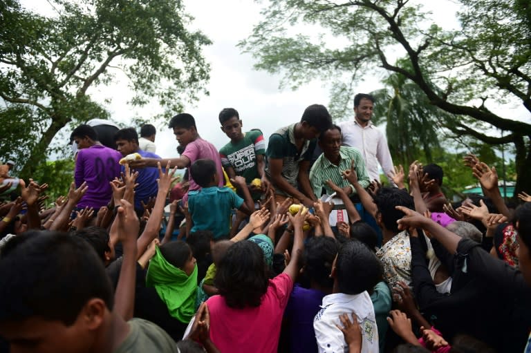 Rohingya refugees from Myanmar gather around a truck delivering food aid in Ukhia on September 14, 2017