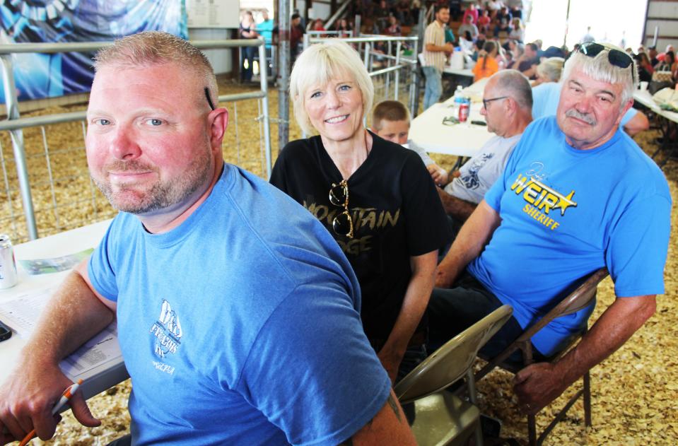 Longtime buyers (from left): Dusty Weir, Cindy Weir and John Weir, and Randy Scott in background, take a break from bidding at the Somerset County Fair's Junior Livestock Sale on Saturday. The Weirs and Scott have been a buying team for years at this local sale for Corsa Coal, formerly PBS Coal. John Weir has purchased hundreds of animals for the coal company and donated them all for worthy causes for almost 30 years.