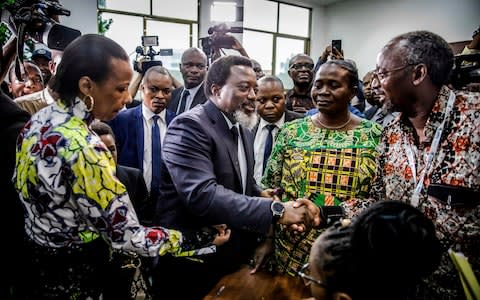 Joseph Kabila greets some electoral observers after casting his vote, December 30  - Credit: LUIS TATO&nbsp;/AFP