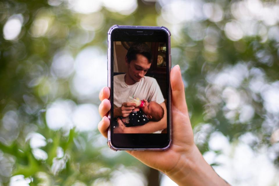 Danielle Harthcock holds up a photo of her fiancèe Steven Gomez holding their daughter Hope Gomez, who is now 5, when she was around four months old outside her home in Olive Branch, Miss., on Thursday, June 29, 2023. Gomez died while in custody of the Shelby County Sheriff’s Office.