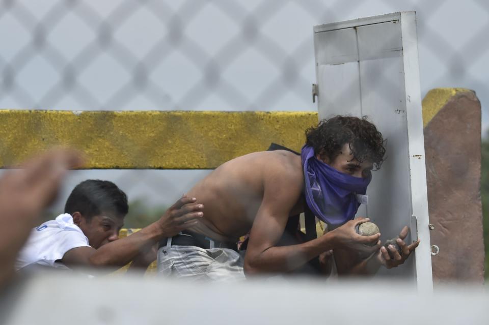 A demonstrator takes shelter behind an improvised shield in clashes with Venezuelan national police (AFP/Getty Images)