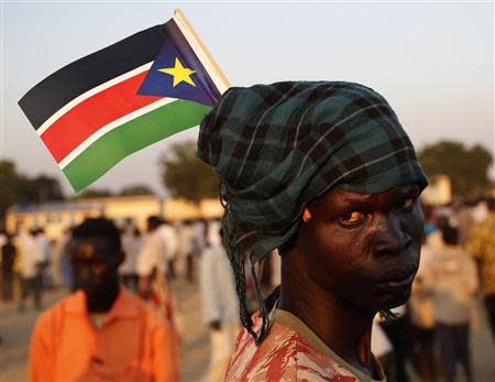 A man holds South Sudan's national flag as he celebrates referendum results in Abyei October 31, 2013. REUTERS/Goran Tomasevic