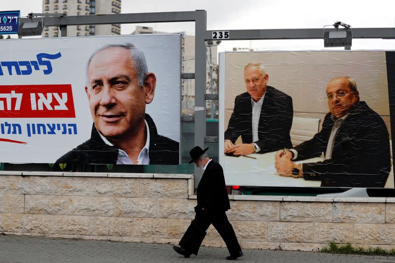 FILE PHOTO: An ultra-Orthodox Jewish man walks next to Likud party election campaign banners in Jerusalem