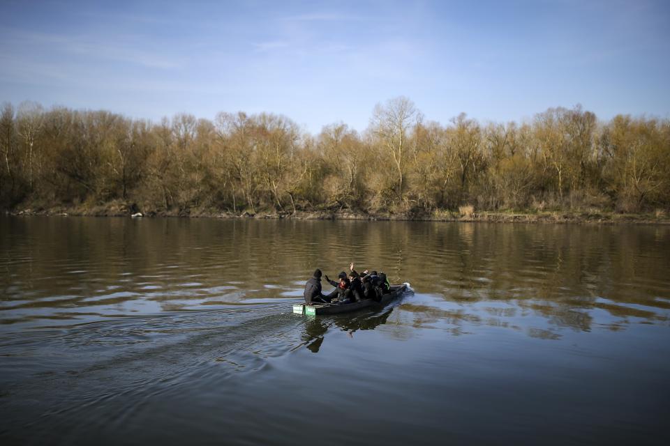 Migrants use an inflatable boat as they attempt to enter Greece from Turkey by crossing the Maritsa river (Evros river in Greek) near the Pazarkule border gate in Edirne, Turkey, Sunday, March. 1, 2020. The United Nations migration organization said Sunday that at least 13,000 people were massed on Turkey's land border with Greece, after Turkey officially declared its western borders were open to migrants and refugees hoping to head into the European Union. (AP Photo/Emrah Gurel)