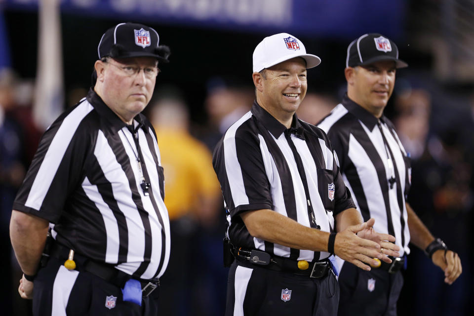 Referee Jim Core, center, gestures alongside other game officials before an NFL football game between the New York Giants and the Dallas Cowboys, Wednesday, Sept. 5, 2012, in East Rutherford, N.J. (AP Photo/Julio Cortez)