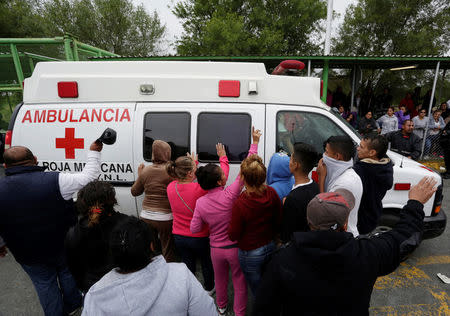 Relatives of inmates react as an ambulance leaves the Cadereyta state prison after a riot broke out at the prison, in Cadereyta Jimenez, on the outskirts of Monterrey, Mexico October 11, 2017. REUTERS/Daniel Becerril